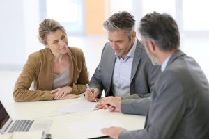 People sitting at a table signing documents for a custom home build