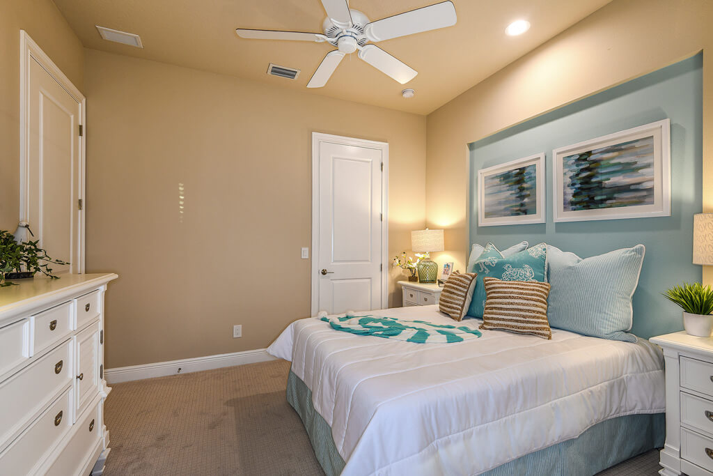 a luxury bedroom with a bed and a fan from a home builder