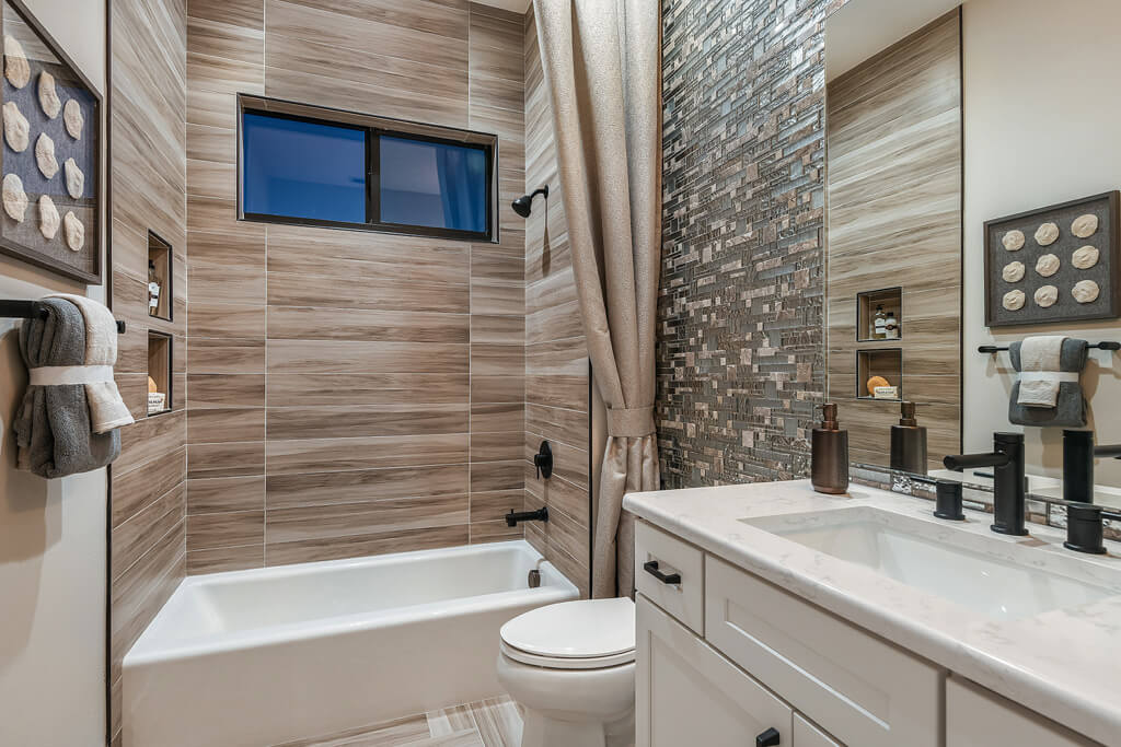 a Custom bathroom with a large tub and sinks with mirrors in a home with a modern build