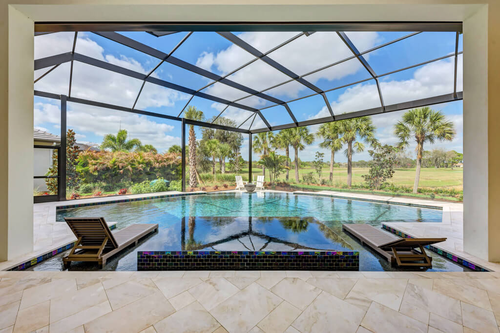 a home with a large Custom lanai with a view of palm trees and pool
