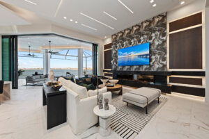 Elegant custom-built-home living room with panoramic waterfront views, modern fireplace, and indoor-outdoor design.