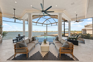Custom-built-home outdoor living space with panoramic water views, covered lounge area, and resort-style pool.
