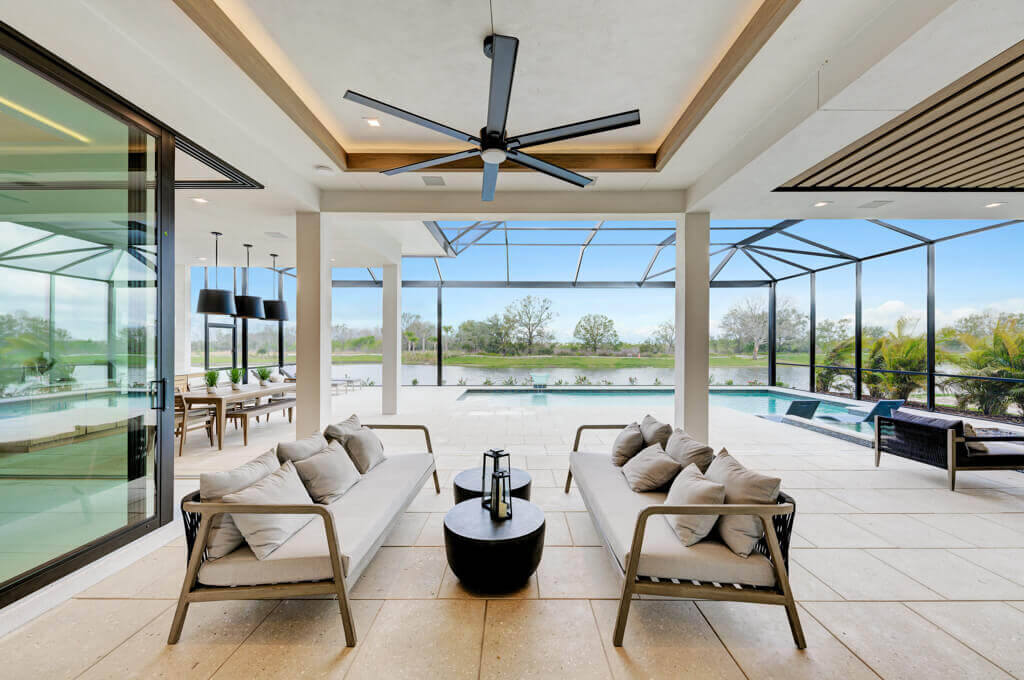 Sitting area opening to pool designed by Lee Wetherington Homes, luxury custom home builder Sarasota