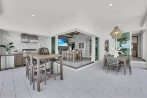 Luxury home designs featuring a modern indoor-outdoor kitchen and dining space with expansive natural light and seamless Florida custom home layout.