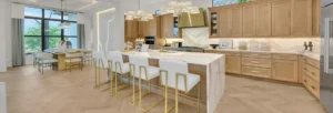 Light wood kitchen with Cambria, gold stools, and elegant pendant lighting