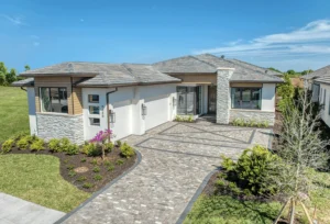 Front view of a Florida custom built home with paved walkway leading to a stylish entry door