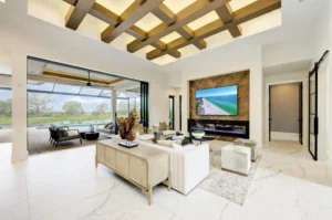  Luxury living room showcasing how custom home building can create seamless indoor-outdoor spaces, with expansive glass doors, modern furnishings, and a covered patio. 
