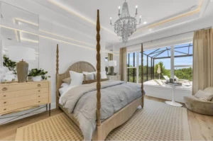 Custom home bedroom with elegant finishes and large outdoor-facing windows 