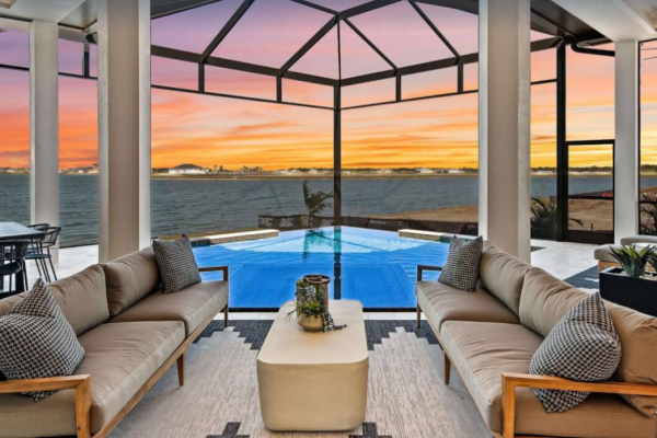 Waterfront outdoor living retreat designed by luxury home builders at sunset